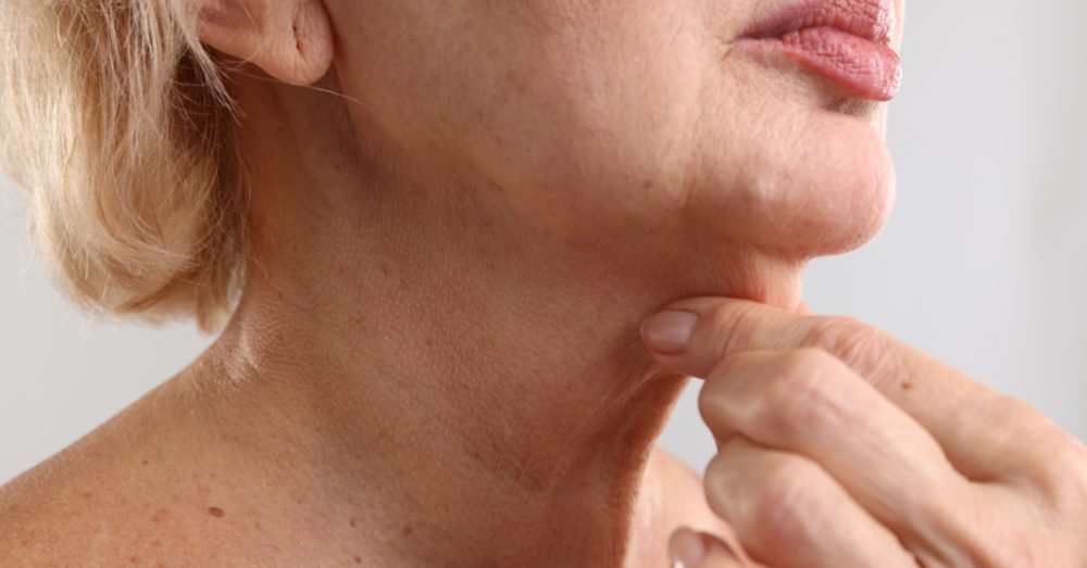 Mature woman touching the excess skin on her neck